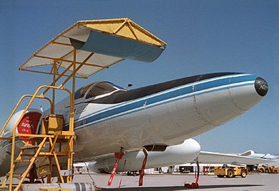 The NASA ER-2 aircraft is shown with the AirMISR instrument installed in the nose, undergoing testing. The black object at the bottom surface of the nose is the viewing window for AirMISR. The tall cart on wheels holds equipment used to display images and other AirMISR data after the aircraft lands. It is not flown with the instrument.Photograph by Chuck Sarture, JPL image P-48594A