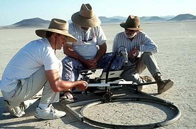 These members of the MISR team are preparing to make field measurements at Lunar Lake, Nevada, early on the morning of June 5, 1996. Here they are working on a portable instrument that can measure light reflected by the surface in many color bands and at multiple view angles. In the course of the day, they carried this instrument around the test site in a backpack, taking hundreds of images of the surface. During this experiment, they also used instruments that measure sunlight and skylight. Independent field measurements such as these will be used to validate and confirm the data acquired by the spaceborne MISR instrument and the airborne AirMISR instrument.
